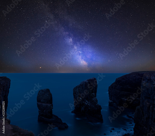 Vibrant Milky Way composite image over landscape of Elegug Stacks on Pembrokeshire Coast in Wales photo