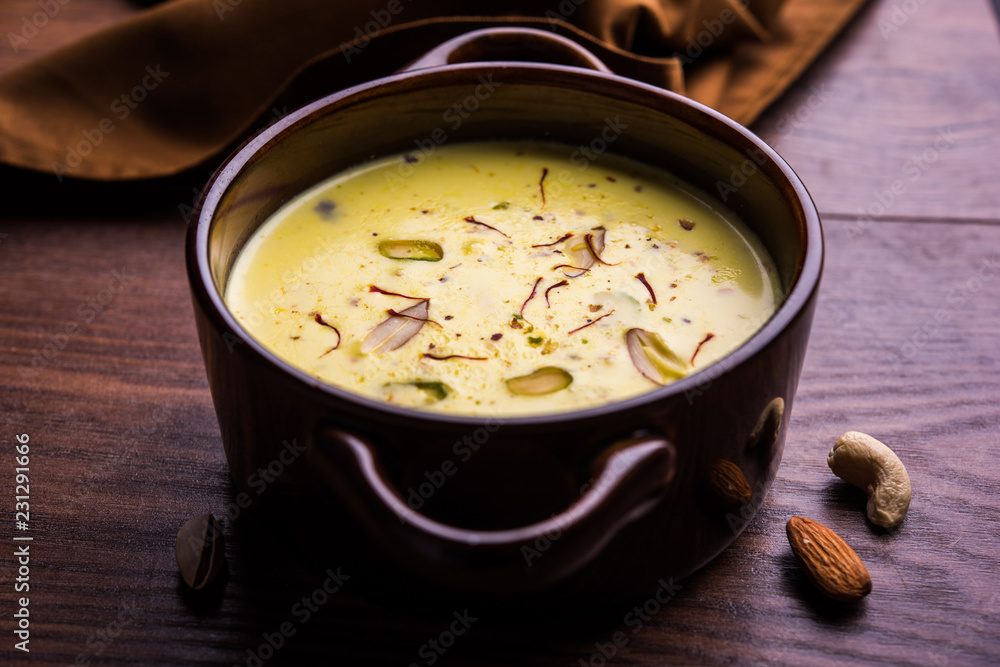 Basundi Or Rabri is an Indian sweet popular in Gujarat and Maharashtra. It is a sweetened condensed milk. Garnished with Dry fruits and Saffron. Served in a bowl over moody background. Selective focus Basundi Or Rabri is an Indian sweet popular in Gujarat and Maharashtra. It is a sweetened condensed milk. Garnished with Dry fruits and Saffron. Served in a bowl over moody background. Selective focus
