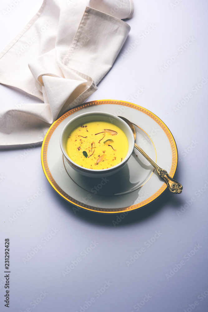 Basundi Or Rabri is an Indian sweet popular in Gujarat and Maharashtra. It is a sweetened condensed milk. Garnished with Dry fruits and Saffron. Served in a bowl over moody background. Selective focus Basundi Or Rabri is an Indian sweet popular in Gujarat and Maharashtra. It is a sweetened condensed milk. Garnished with Dry fruits and Saffron. Served in a bowl over moody background. Selective focus