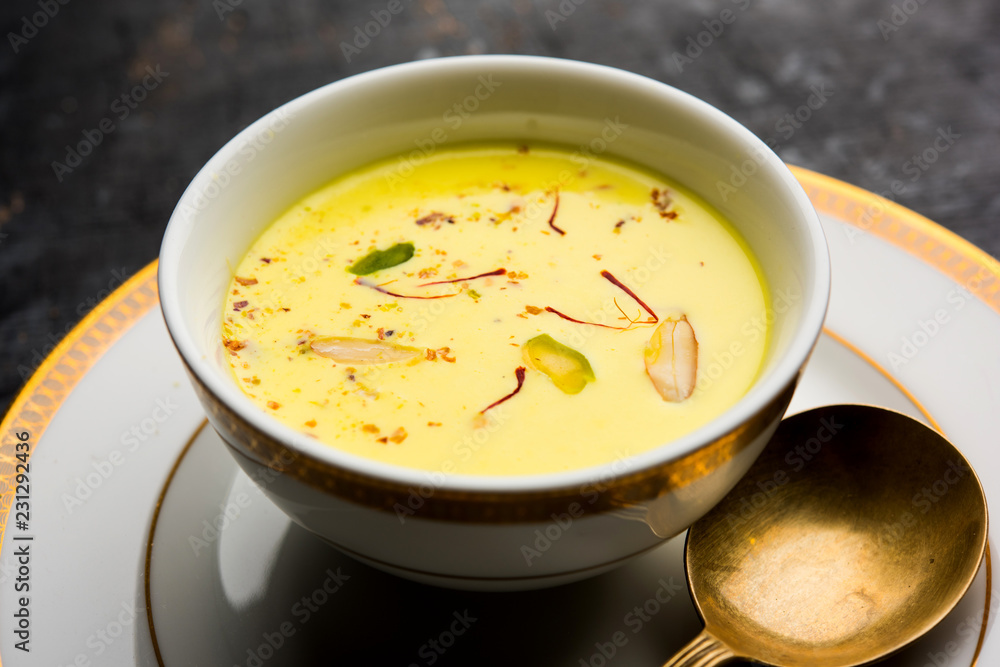 Basundi Or Rabri is an Indian sweet popular in Gujarat and Maharashtra. It is a sweetened condensed milk. Garnished with Dry fruits and Saffron. Served in a bowl over moody background. Selective focus Basundi Or Rabri is an Indian sweet popular in Gujarat and Maharashtra. It is a sweetened condensed milk. Garnished with Dry fruits and Saffron. Served in a bowl over moody background. Selective focus
