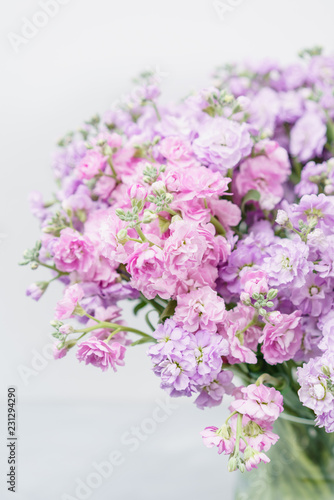 Bouquet of Beautiful lilac color gillyflower, levkoy or matthiola. Spring flowers in vase on wooden table. Vertical photo