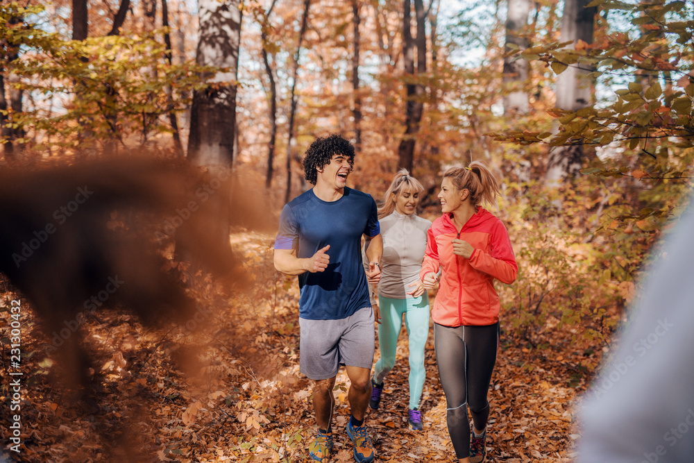 Small group of people running in woods.