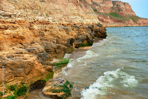 beautiful sea landscape, closeup of stone on the beach, sea coast with high hills, wild nature photo