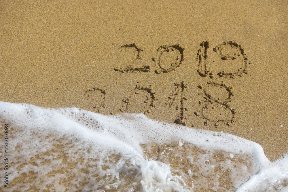Fototapeta premium New Year 2019 concept. The inscription on the sand a number message Year 2018 replace 2019