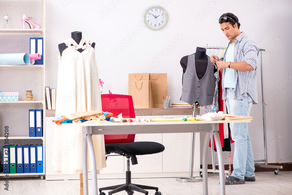 Fototapeta premium Young handsome tailor working in his workshop