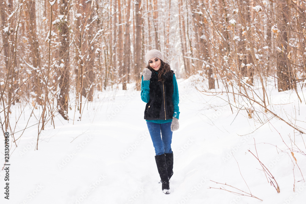 Happy young woman walking in winter time. Pretty girl in snowy nature Happy young woman walking in winter time. Pretty girl in snowy nature