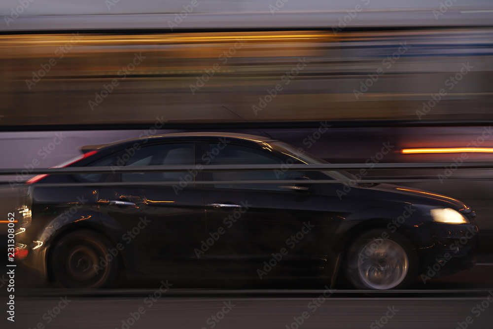car blurred in motion, black. with city lights. long exposure