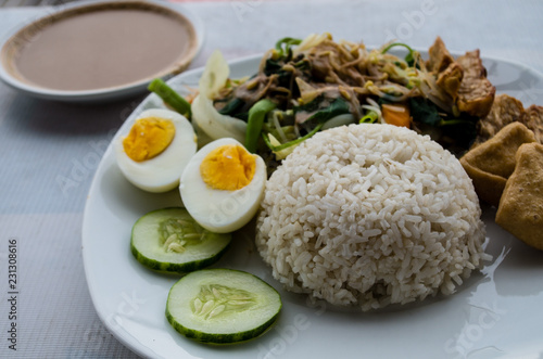 GADO GADO with rice, typical Indonesian salad with hard-boiled eggs, boiled potato, fried tofu and tempeh and peanut sauce.