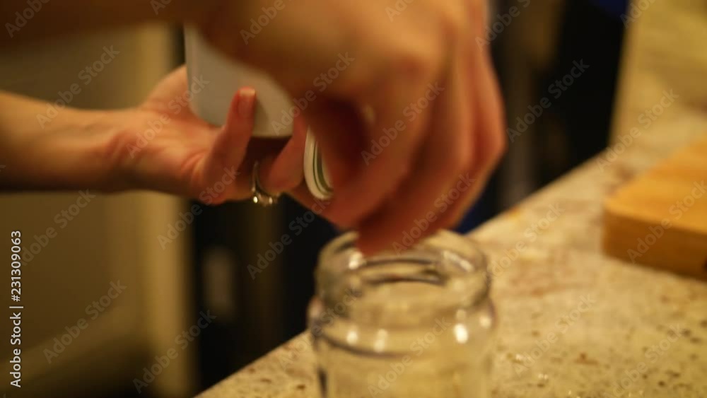 Woman Adding Ingredients to Authentic Homemade Salad Dressing Woman Adding Ingredients to Authentic Homemade Salad Dressing