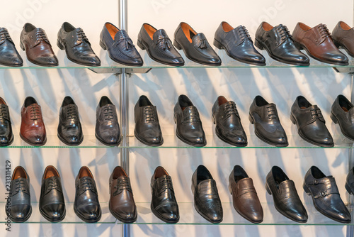Men's leather shoes on the shelf in the store. Racks in the store of clothes and accessories. Shelves with stylish men's shoes. Many classic shoes and boots