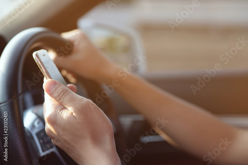 Young man driving using mobile smart phone while driving the car. transportation and vehicle concept