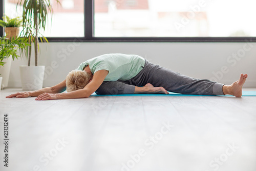 Senior beautivul woman practise joga in room photo