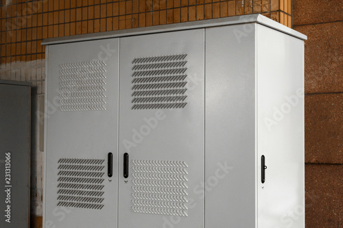 Outdoor cabinet for electrical equipment on white background. white perforated iron cabinet on the street.