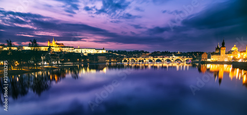 Prague evening panorama. Prague Castle with Carles Bridge reflect in Vltava river during sunset