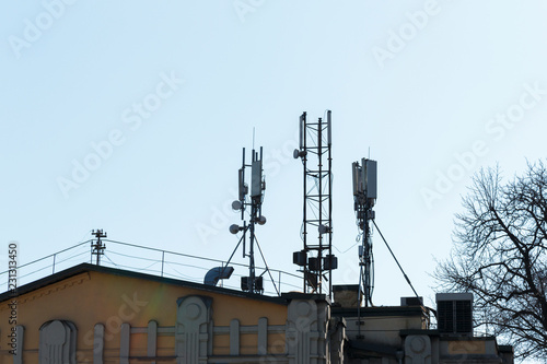 Telecommunication system with wireless communications systems are located on the roof and city landscape as background. Development communication system. Antennas for mobile phone technology.