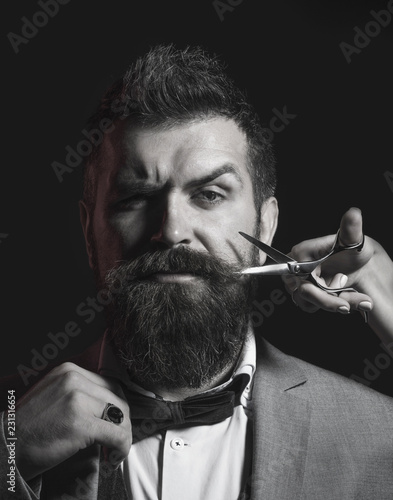 Bearded man, long beard, brutal, caucasian hipster with moustache. Men haircut in barber shop. Barber scissors, straight razor, barber shop. Men haircut, shaving. Male in barbershop. Black and white.