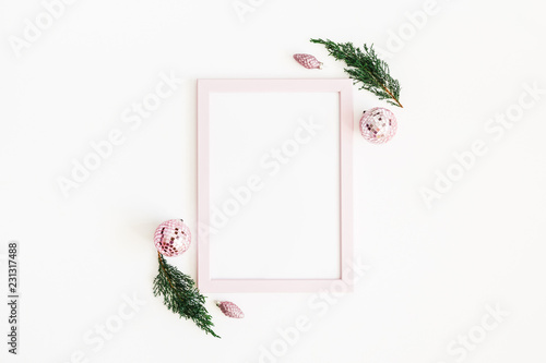 Christmas composition. Photo frame, pink decorations, fir tree branches on white background. Christmas, winter, new year concept. Flat lay, top view, copy space