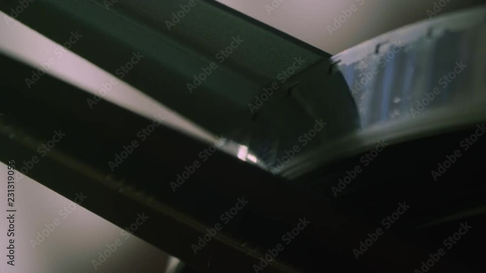 Macro closeup: An 8mm Film Spool with film rotates slowly as it is scanned Macro closeup: An 8mm Film Spool with film rotates slowly as it is scanned