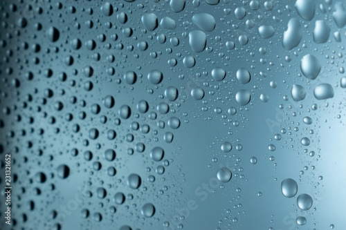 Water drops on round blue background, soft focus, close up