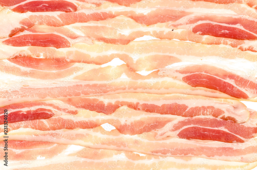 The background of thin strips of smoked bacon lie tightly together. The background of thin strips of smoked bacon lie tightly together.