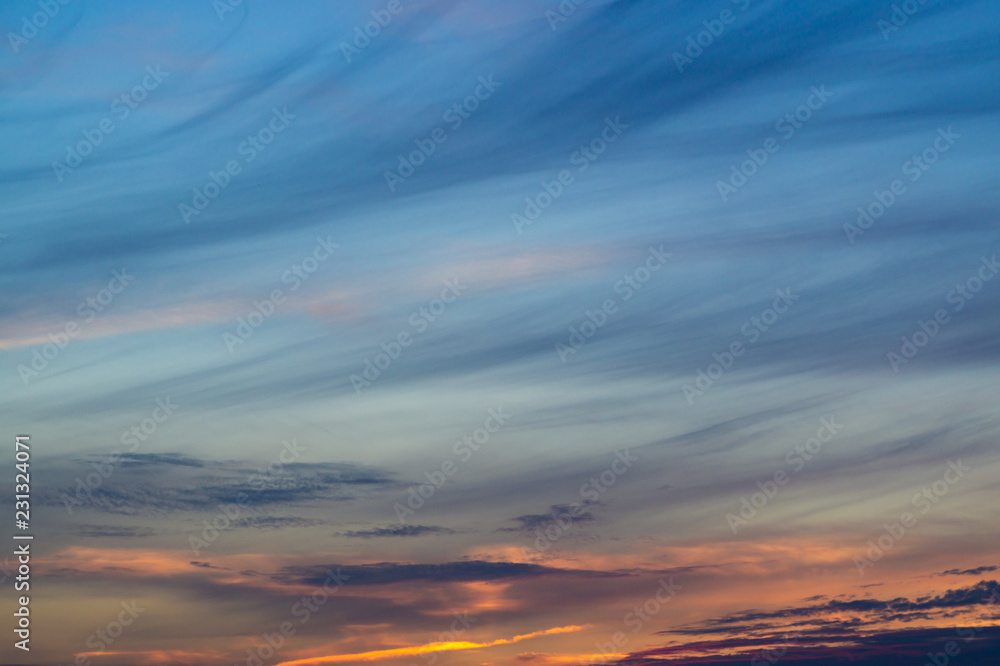 Blue evening sky with blurred sun on horizon trough fence. Creative idea- underexposed photo.