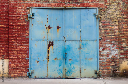 Old warehouse rusty entry with aged red brick wall texture
