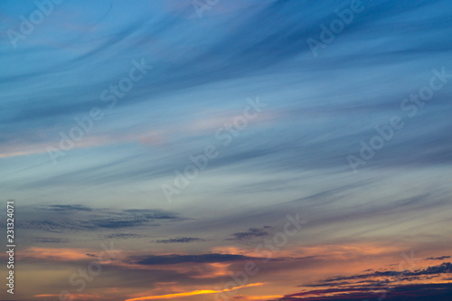 Blue evening sky with blurred sun on horizon trough fence. Creative idea- underexposed photo.