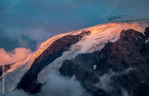 View on Mount Ortler with glacier and clouds at sunset, Passo del Stelvio, Italy.