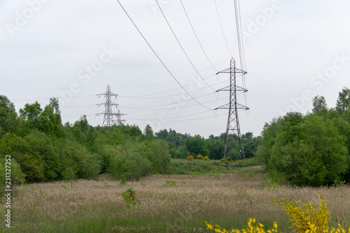 Power lines and pylons running through the English countryside on a cloudy day