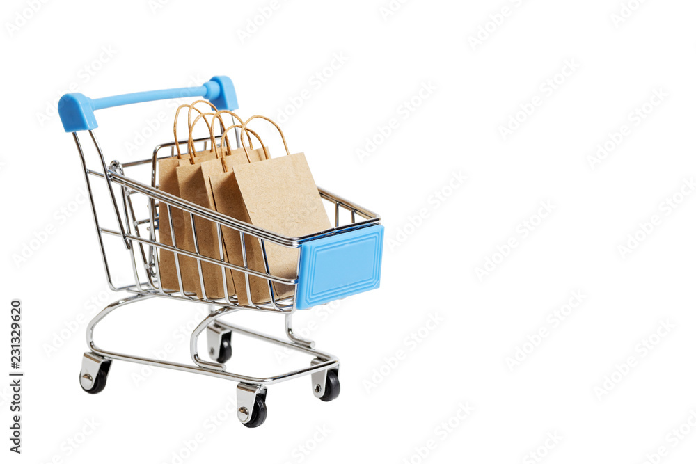 Supermarket shopping cart with paper shopping bags. Concept for shoping, Black Friday, Cyber Monday on white background with copyspace.