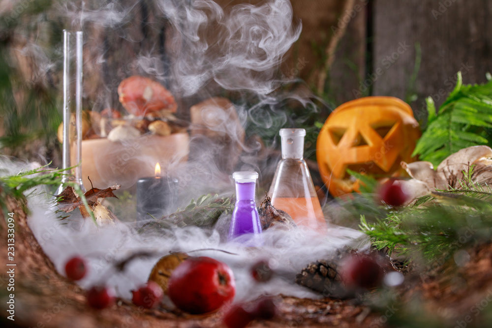 Magic glowing pumpkin for Halloween on the witch's table with ingredients for potions. Magic glowing pumpkin for Halloween on the witch's table with ingredients for potions.