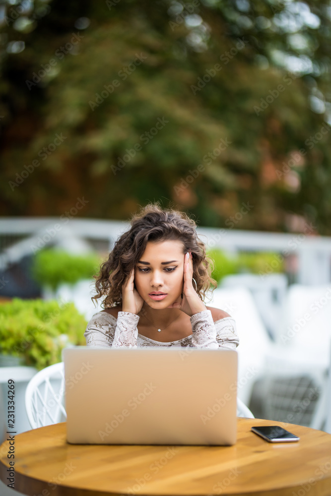 Young latin curly working woman and laptop computer he headache unhappy on job in cafe Young latin curly working woman and laptop computer he headache unhappy on job in cafe