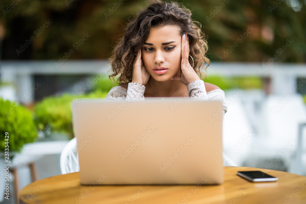 Young latin curly working woman and laptop computer he headache unhappy on job in cafe Young latin curly working woman and laptop computer he headache unhappy on job in cafe
