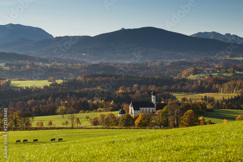 Die Wilpartinger Wallfahrtskirche vor den bayrischen Alpen im Herbst in der Morgensonne, Bayern, Deutschland © Matthias Riedinger