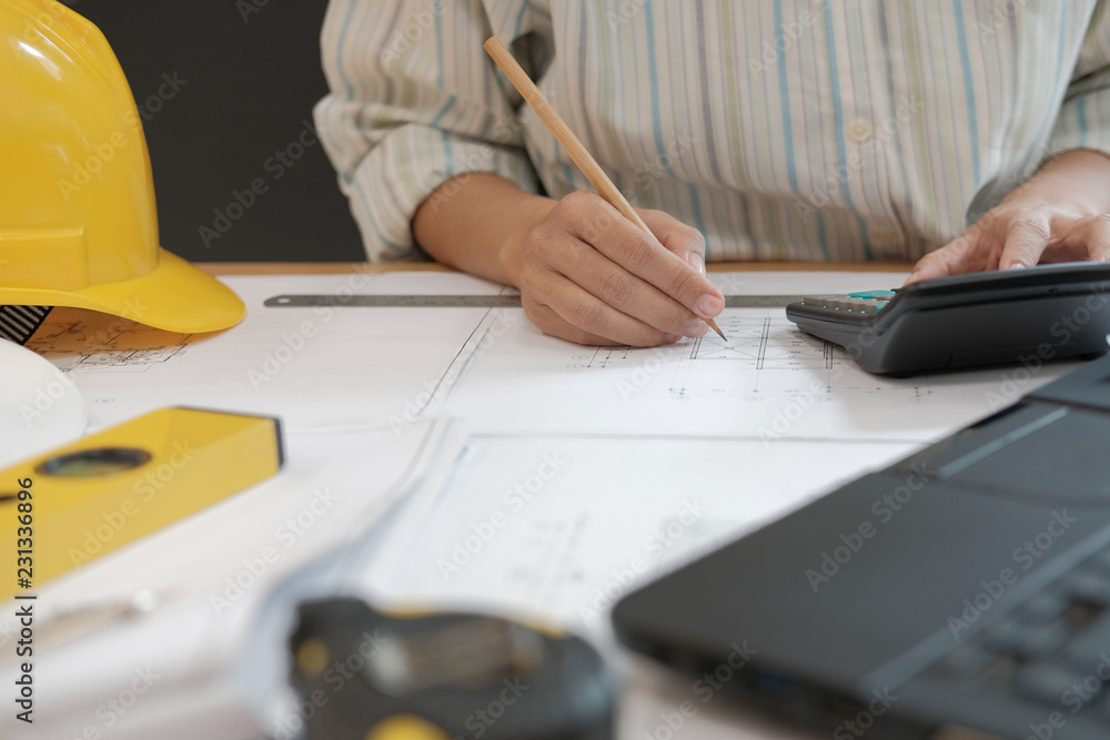 Fototapeta premium architect working on house blueprint of real estate project at workplace. engineer using calculator. building construction concept