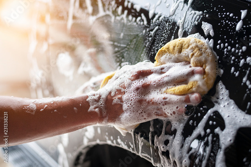 People cleaning car with sponge at car wash photo