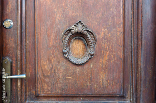 Fragment of a wooden carved door decorated with a small round window. Vintage background. © struvictory