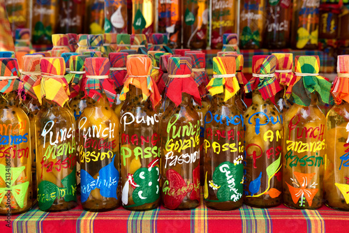many different colored punch(rum and tropical fruits) bottles in a row on a typical market,guadeloupe, french west indies.