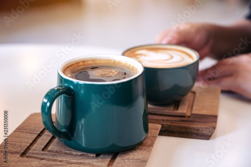Close up image of a hand holding a green coffee mugs in cafe