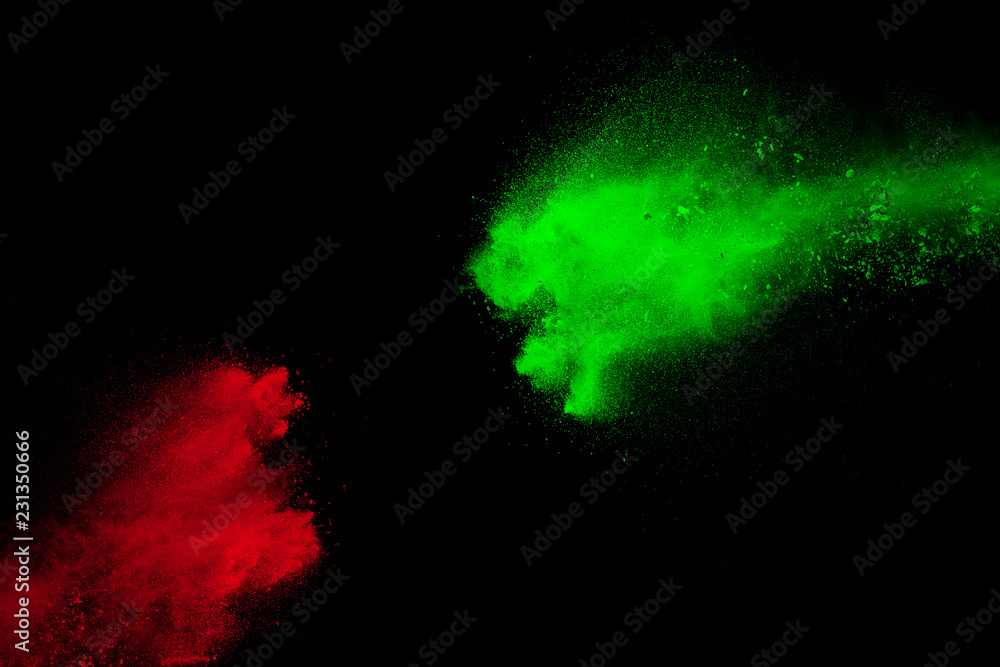Red and green powder explosion on black background. Freeze motion of
