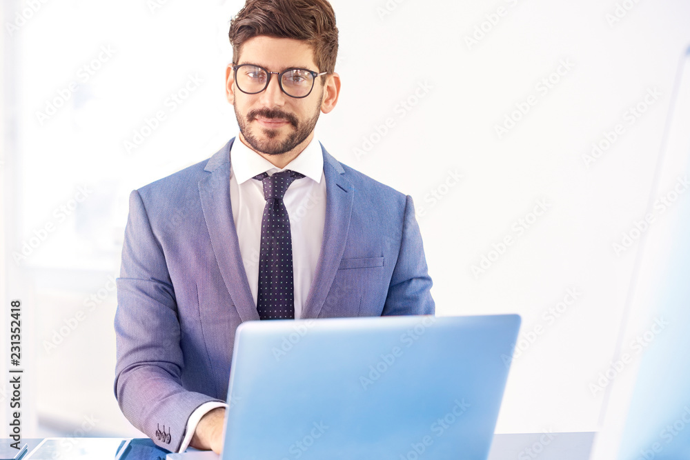 Young business person sitting behind notebook in the office Young business person sitting behind notebook in the office