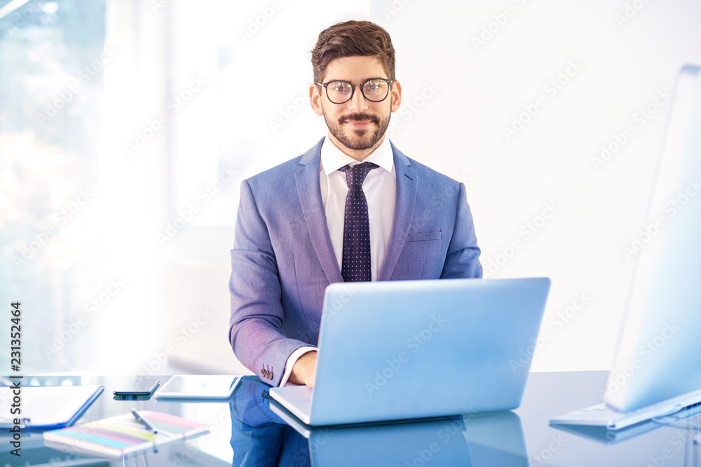 Young business person sitting behind notebook in the office Young business person sitting behind notebook in the office