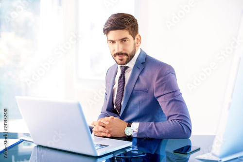 Young business person sitting behind notebook in the office