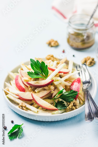 Apple, celery root walnut salad with olive oil, mustard, honey dressing. Selective focus, space for text.