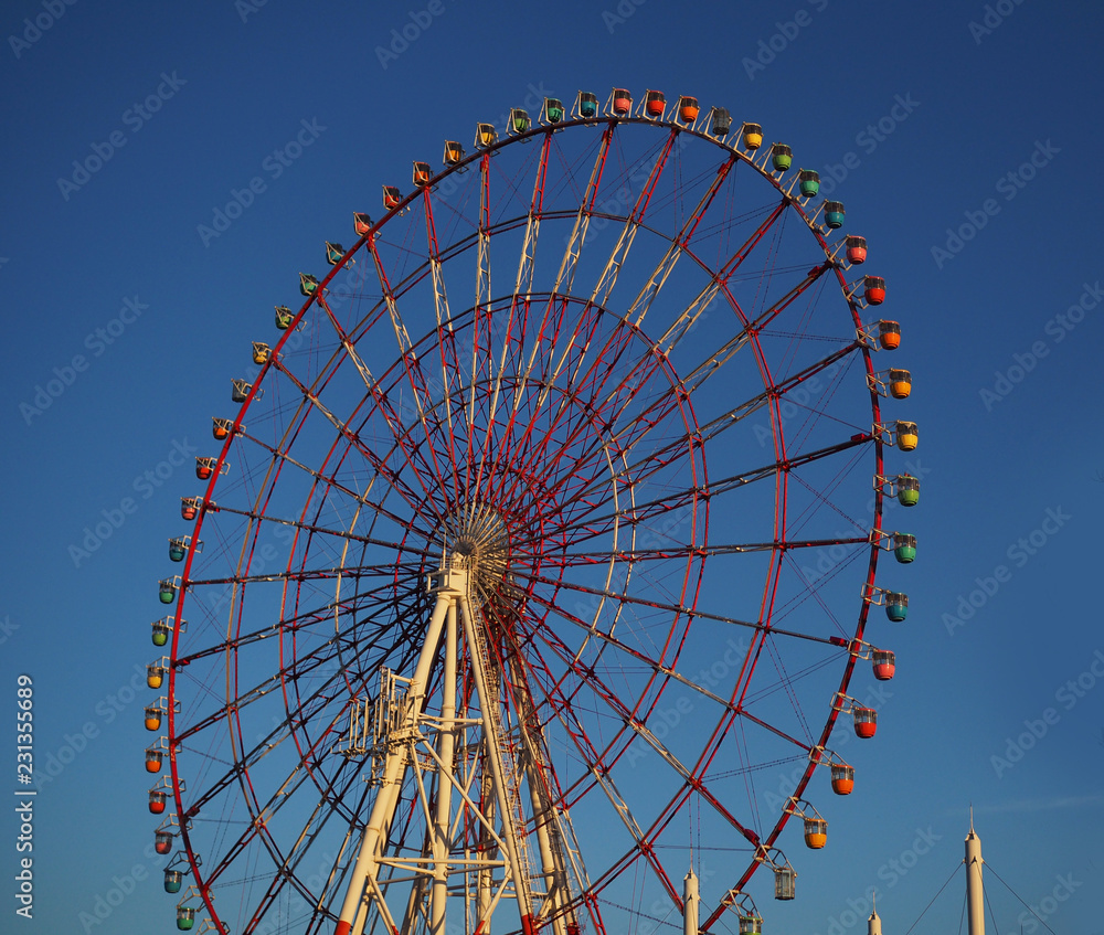 Ferris wheel ride and blue sky background.