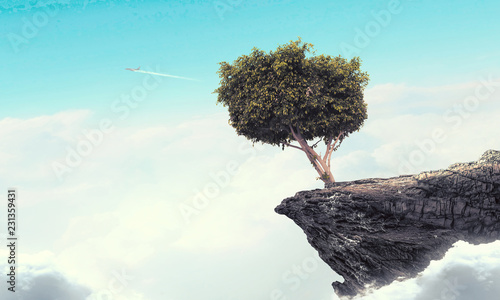 Lonely tree on rock top. Mixed media