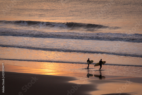 surfers at Welcombe mouth beach, devon, uk