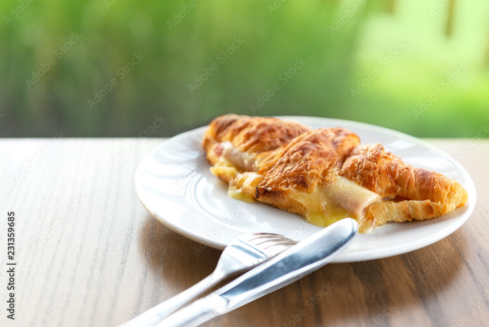Croissant ham cheese, France food in plate on table.