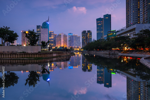 Beautiful Jakarta city in sunset. Landscape of office building and business center of capital city  Jakarta reflected on water in the evening