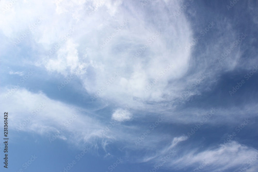 White clouds circular formation over deep blue sky horizontal